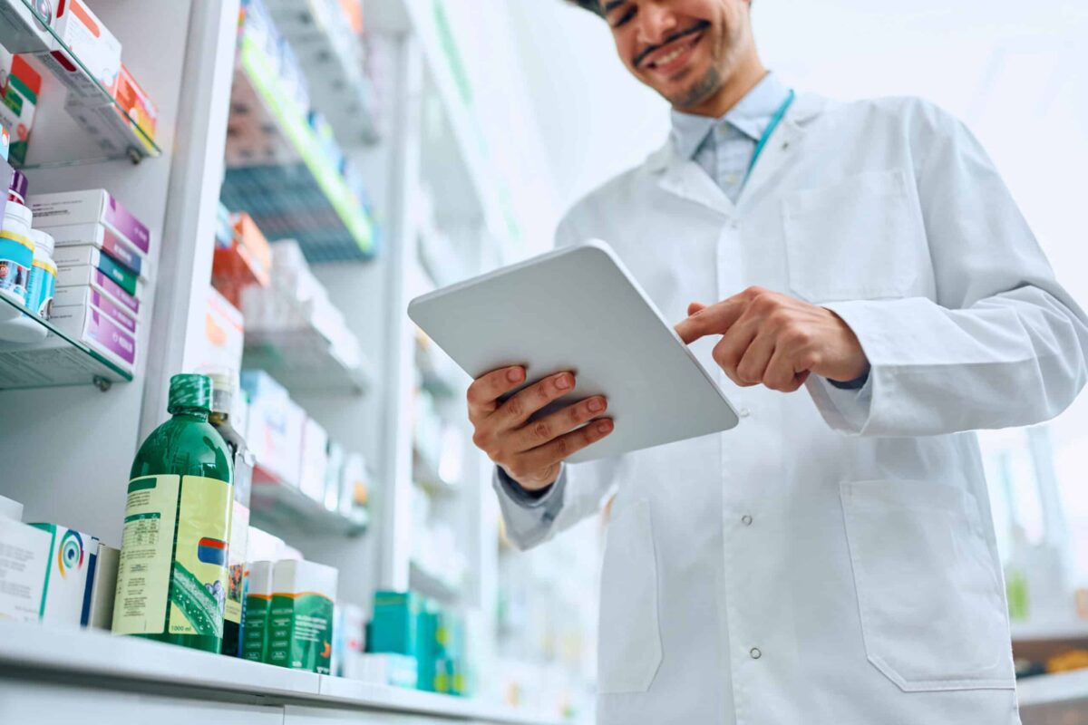 Close up of pharmacist using touchpad while working in a pharmacy.