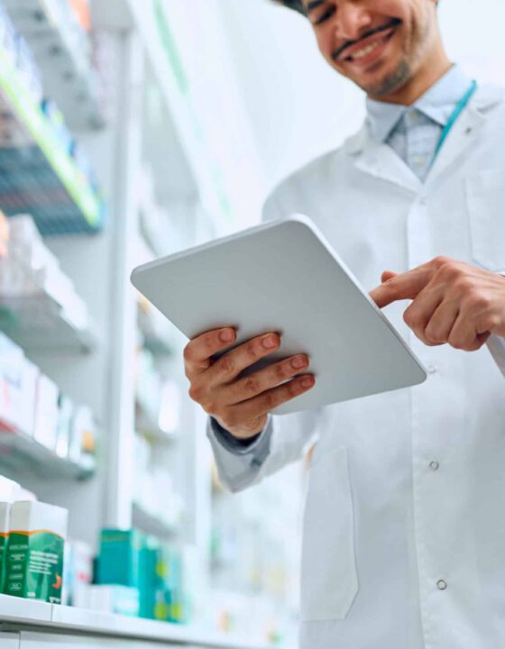 Close up of pharmacist using touchpad while working in a pharmacy.