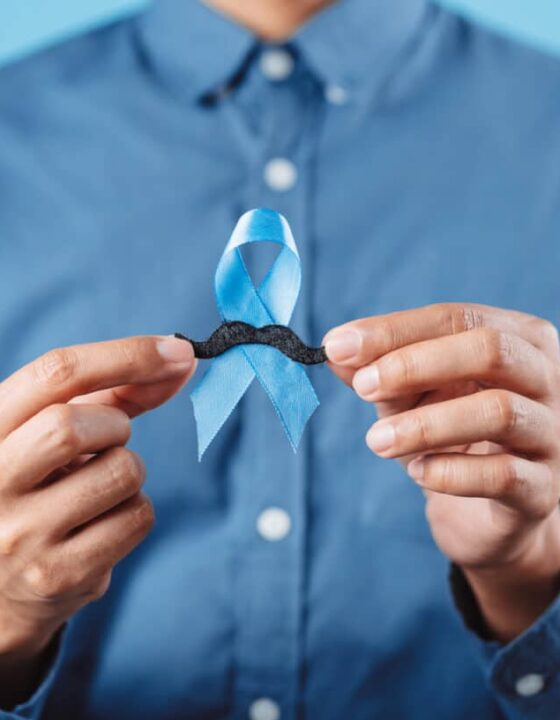 men hands showing Blue ribbon with moustache for supporting people living and illness, Colon cancer, Colorectal cancer, Child Abuse awareness, world diabetes day, International Men's Day