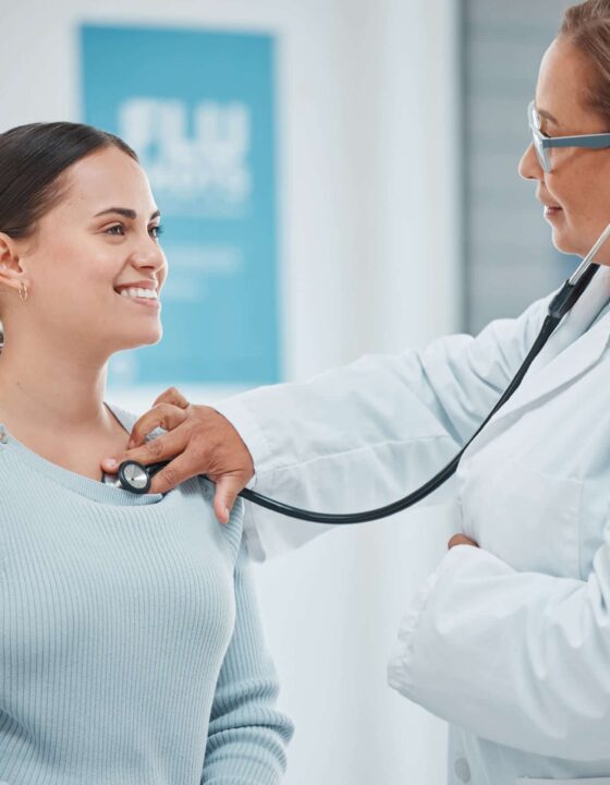 Shot of a doctor examining a patient with a stethoscope during a consultation in a clinic.