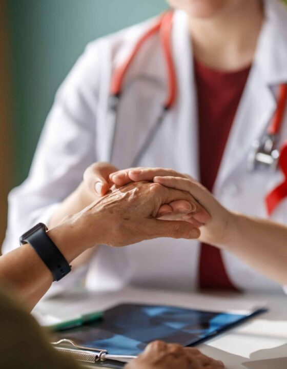 Colour ribbon for concept of illness awareness. Female patient listening to doctor in medical office. Raising knowledge on people living with disease.