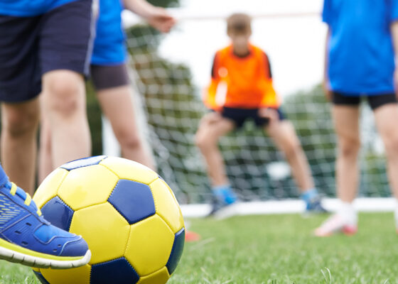 Close Up Of Children's Feet In Soccer Match