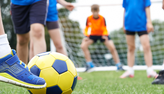 Close Up Of Children's Feet In Soccer Match